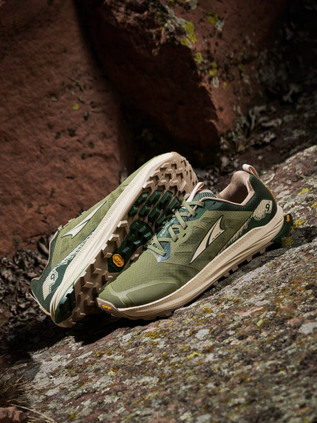 Green and beige  altra lone peak 9+ trail running shoes on a rocky surface