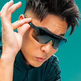 Person wearing sunglasses with a teal background - Goodr Bolt G's Sunglasses - Electric Zen Machine