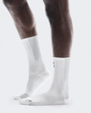 White socks worn with brown pants on a white background - On Performance Run Sock High (Unisex) - White/Glacierbackground