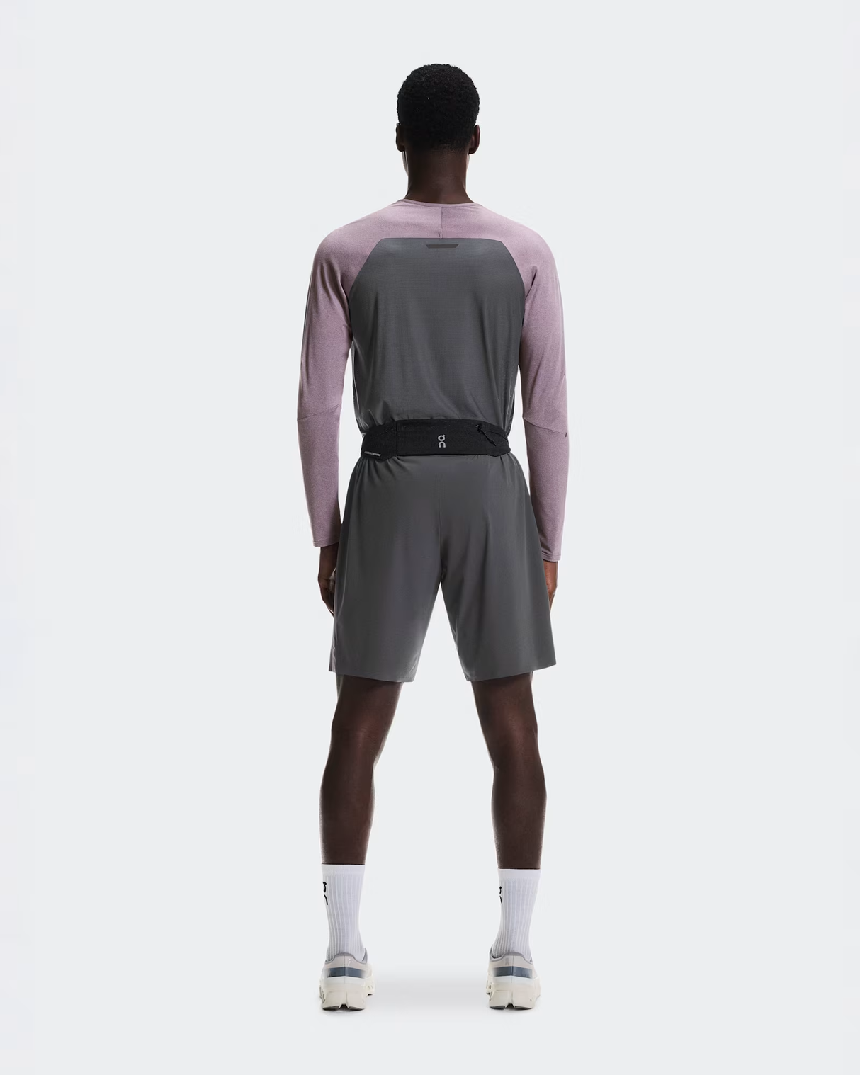 Person wearing a gray athletic outfit with a pink long-sleeve shirt on a white background - On Speed Belt (Unisex) - Black