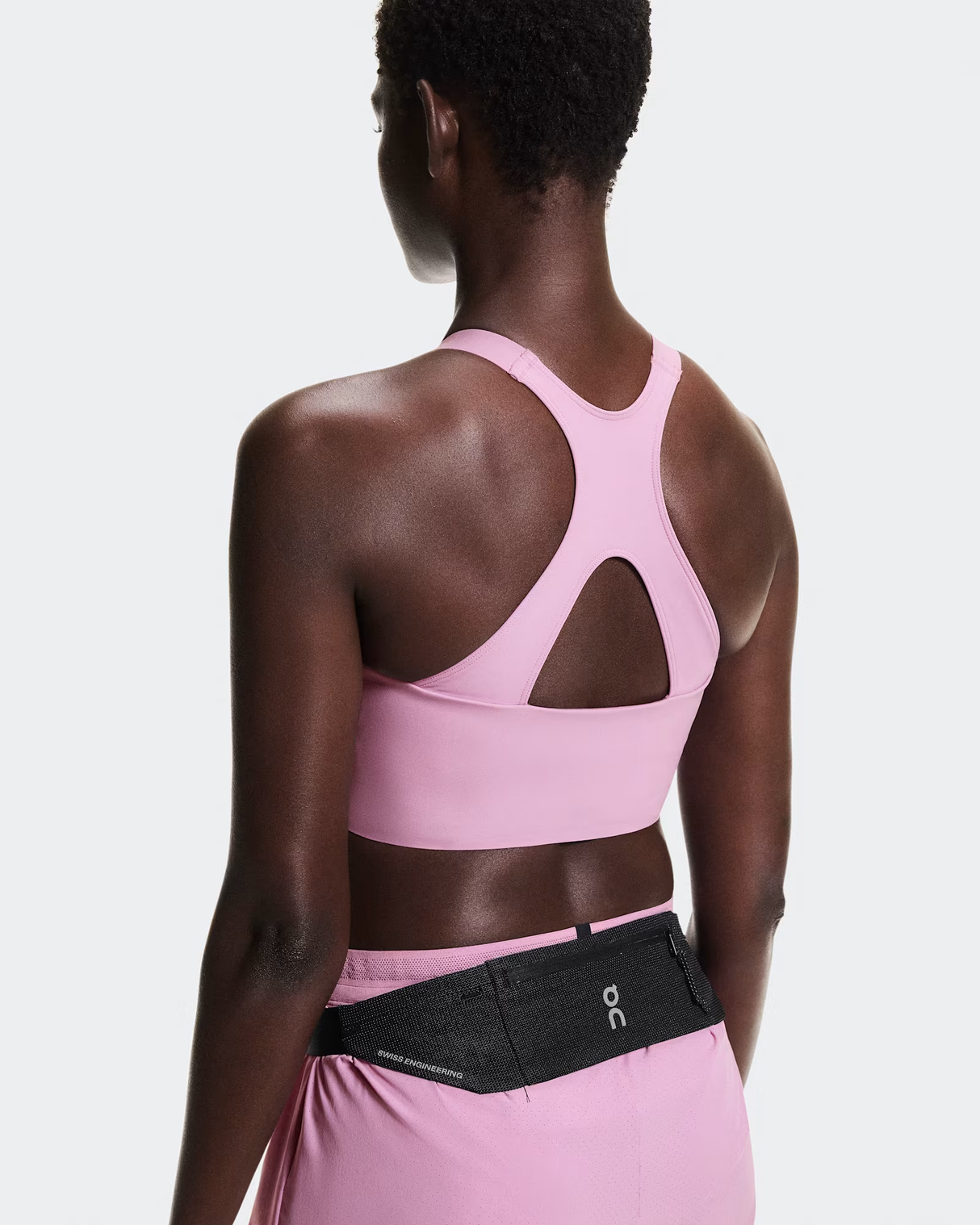 Person wearing a pink sports bra and black waist bag on a light gray background - On Speed Belt (Unisex) - Black