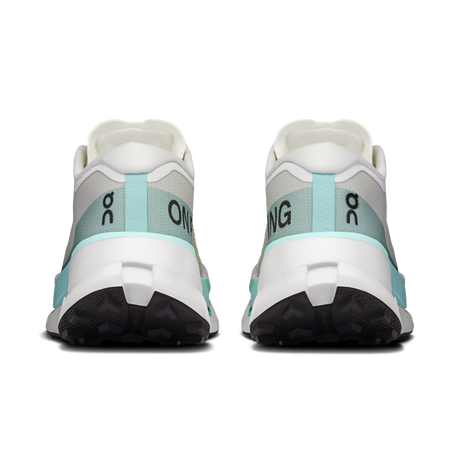 A pair of running shoes shown from the back, featuring a white and light gray upper with mint green accents and black outsoles. The brand logo 'on' is visible on the heel area. - On Cloudultra Pro Shoes (Women's) - Ivory/Celeste
