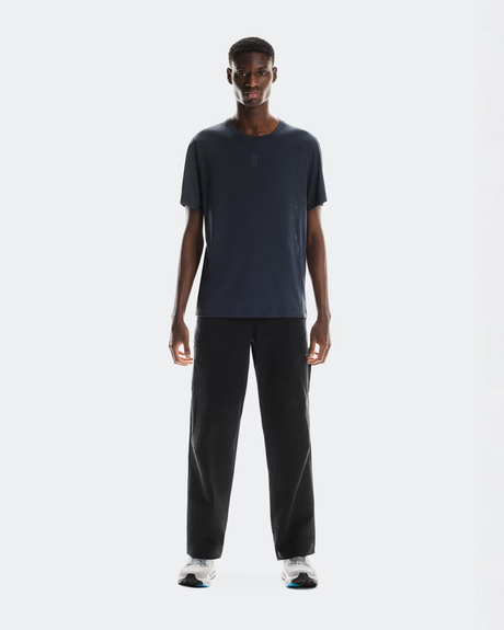 Man wearing a dark blue t-shirt and black pants on a white background - On Trail-T (Men's) - Navy