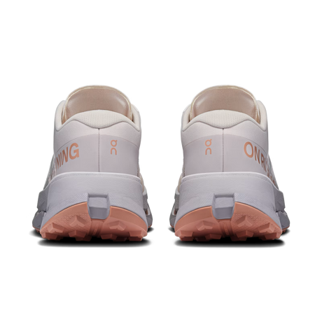A pair of On Running trail shoes shown from the rear, featuring a light gray and off-white upper, peach-colored outsole, and peach branding text on a clean white background. - On Cloudultra 3 Shoes (Women's) - Oyster/Ether