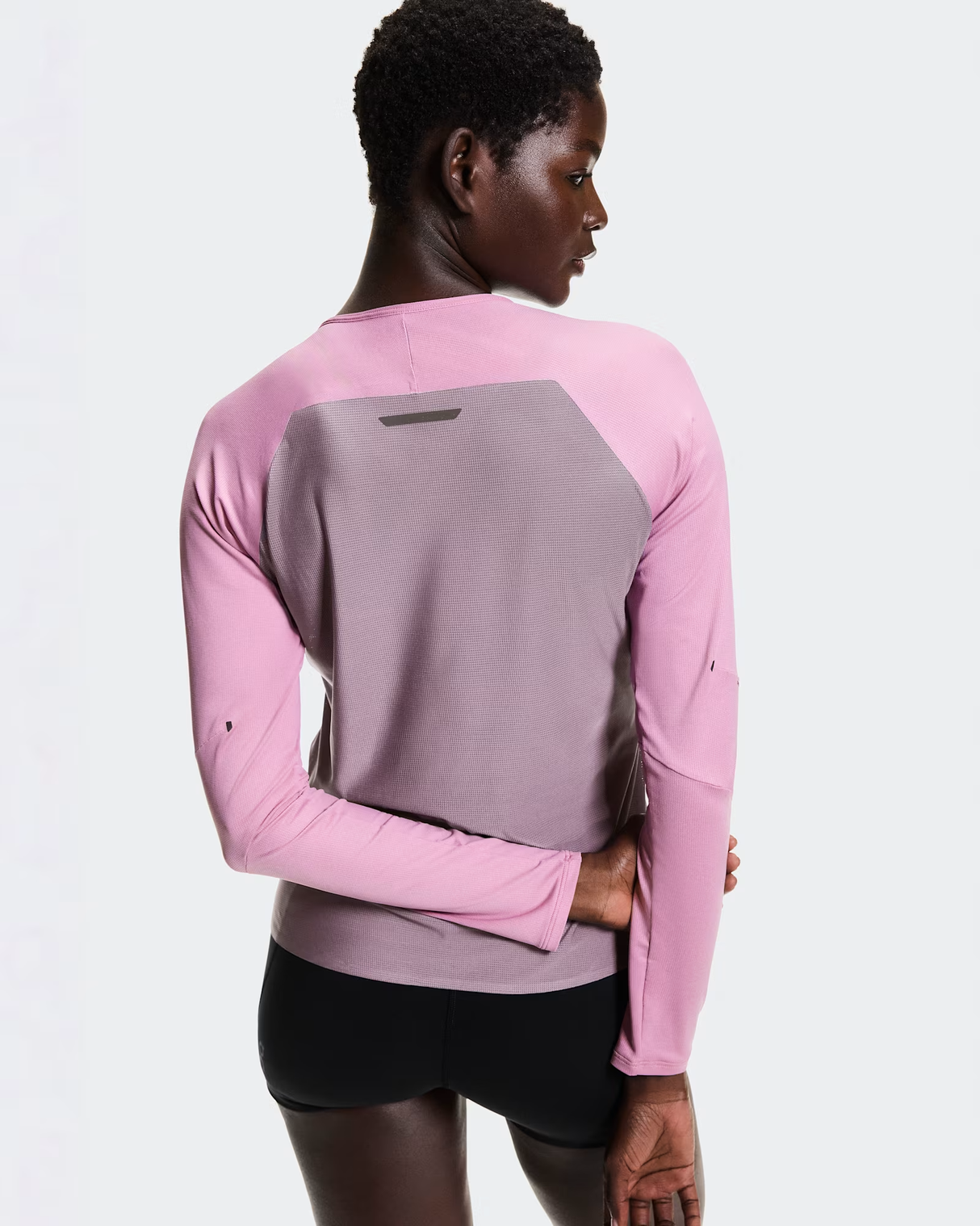 Person wearing a pink and gray long-sleeve athletic shirt on a white background - On Performance Long-T (Women's) - Dewberry/Sakura