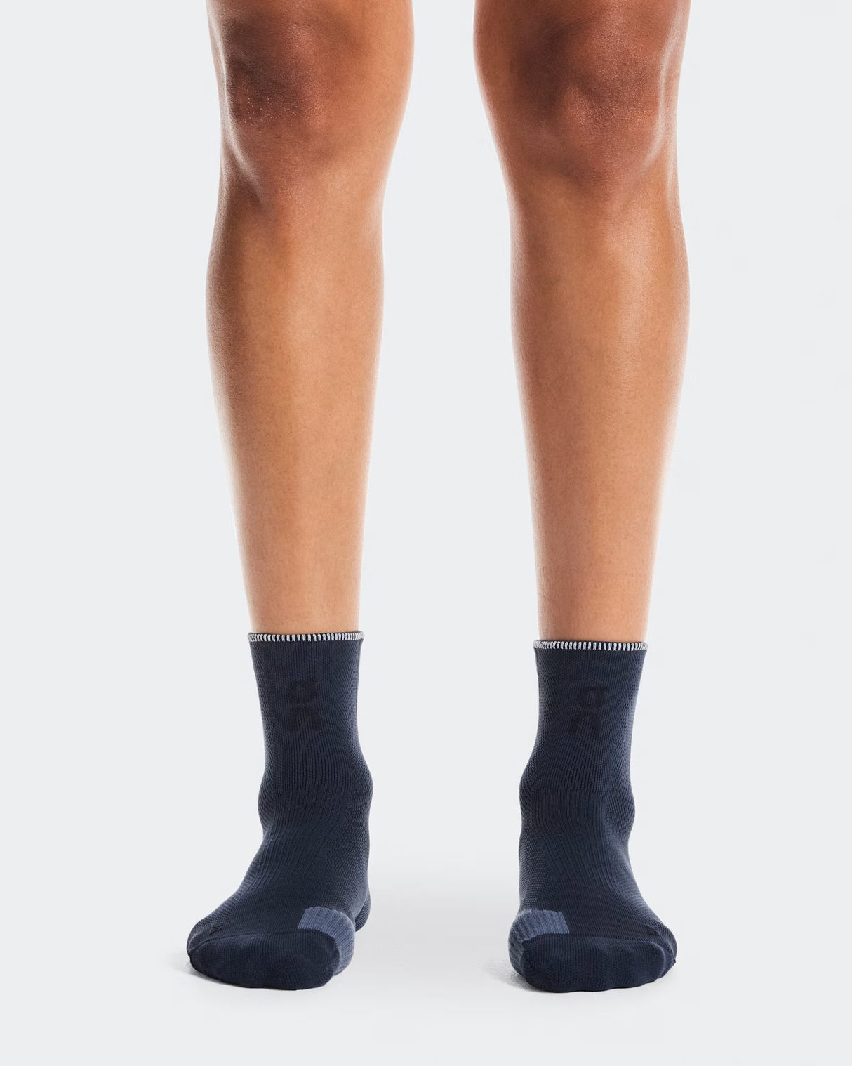 Navy socks worn by a person on a white background - On Performance Run Sock Mid (Unisex) - Navy/Navy
