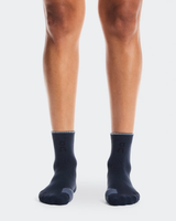 Navy socks worn by a person on a white background - On Performance Run Sock Mid (Unisex) - Navy/Navy