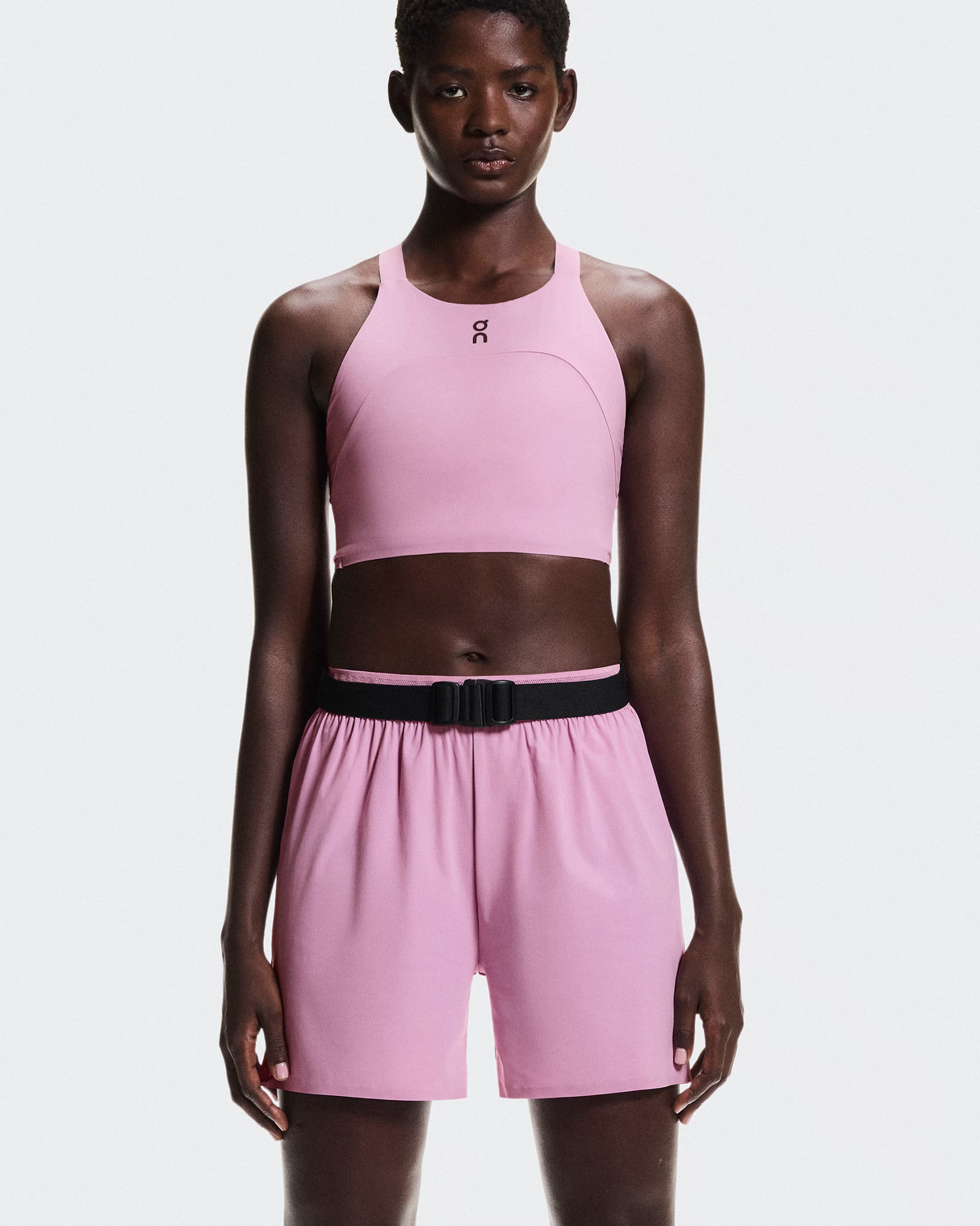 Person wearing a pink athletic outfit with a black belt on a white  - On Speed Belt (Unisex) - Blackbackground