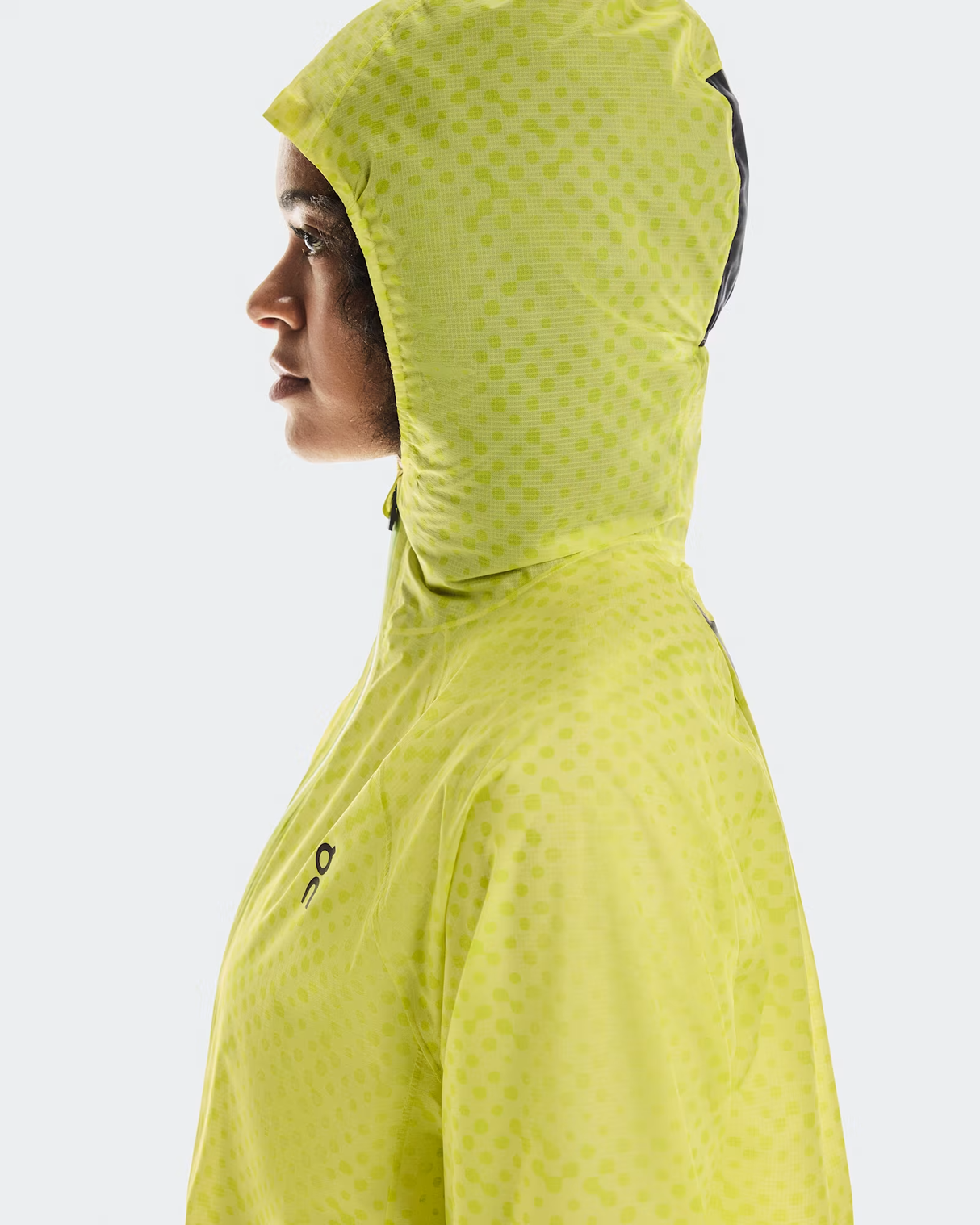 Person wearing a bright yellow hooded jacket on a white background - On Ultra Jacket (Women's) - Limelight/Lime