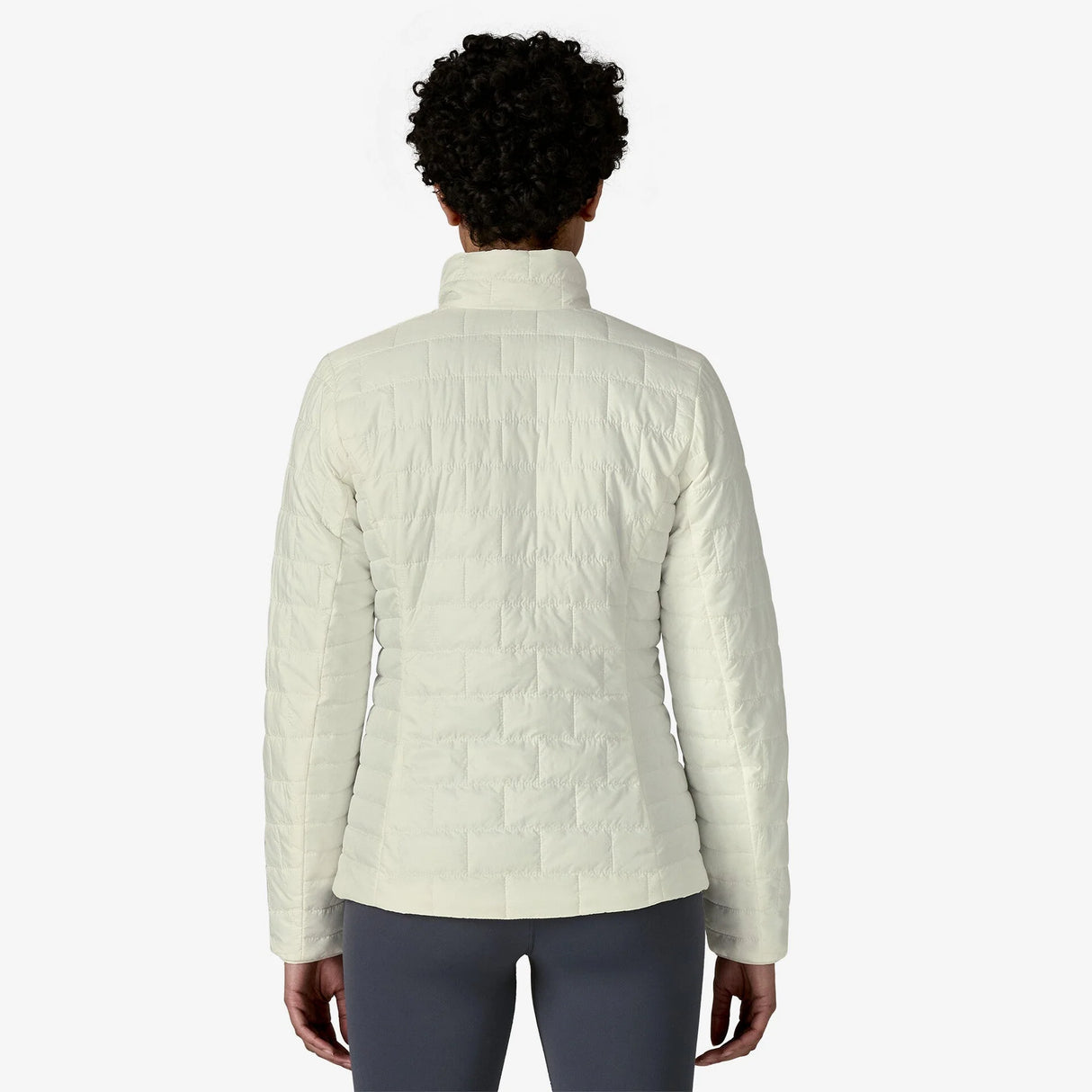 Person wearing a light-colored quilted jacket on a white background - Patagonia Nano Puff Jacket (Women's) - Birch White