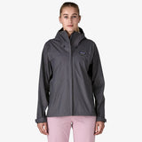 Person wearing a gray rain jacket with a visible brand logo on a white background - Patagonia Torrentshell 3L Rain Jacket (Women's) - Smolder Blue