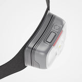 Close-up of a headlamp with a gray casing and black strap on a light gray background - Biolite Range 500 Headlamp - Midnight Grey
