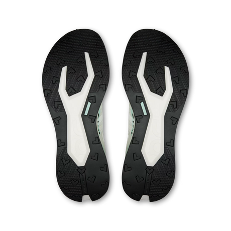 A pair of athletic shoe soles shown from the bottom, featuring a black textured outsole with a white and mint green Y-shaped midsole design, photographed on a solid white background. - On Cloudultra Pro Shoes (Men's) - Ivory/Celeste