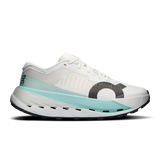 A white On running shoe with a light blue midsole accent and a dark gray textured circular logo on the side, shown against a plain white background. - On Cloudultra Pro Shoes (Women's) - Ivory/Celeste
