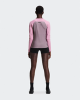 Person wearing a pink and gray athletic outfit on a white background - On Performance Long-T (Women's) - Dewberry/Sakura