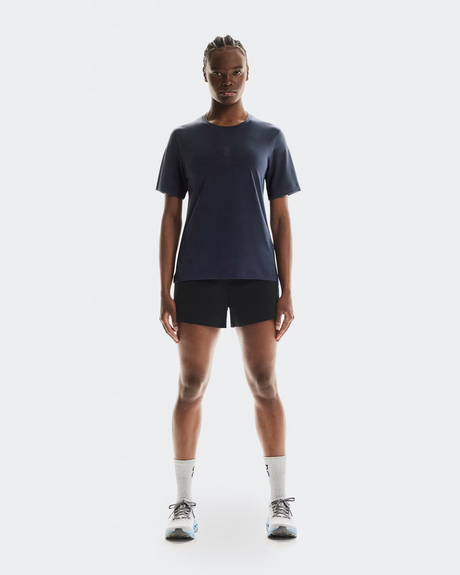 Person wearing a dark blue t-shirt, black shorts, and white socks on a white background - On Trail-T (Women's) - Navy