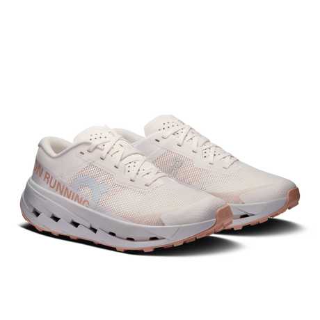 A pair of running shoes in off-white mesh with light pink accents on the outsole and side branding, shown against a solid white background. - On Cloudultra 3 Shoes (Women's) - Oyster/Ether