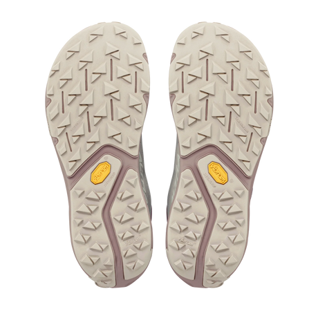 A pair of hiking shoes shown from the bottom, displaying their off-white and dusty purple lugged soles with yellow Vibram logos. - Altra Experience Wild 3+ Shoes (Women's) - Grey/Pearl