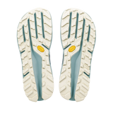 A pair of hiking shoe soles shown from the bottom, featuring an off-white textured tread pattern with light blue-green grooves and small yellow Vibram logos. - Altra Olympus 275 HiLo Shoes (Men's) - Grey/Sea Pine