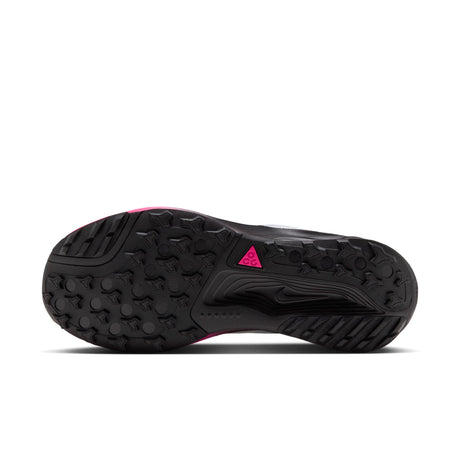 The black outsole of a trail running shoe, featuring a textured tread pattern and a small bright pink logo accent, shown against a white background. - Nike ACG Pegasus Trail Shoes (Men's) - Pure Platinum/Black-Hyper Pink