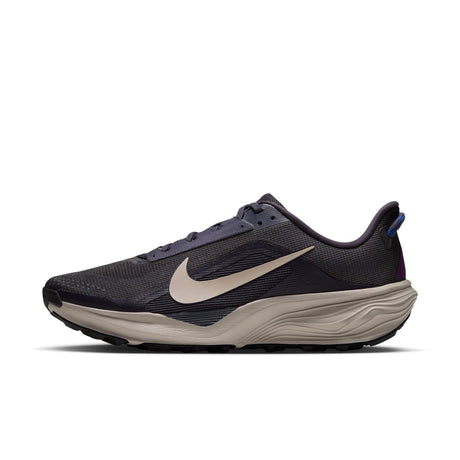 A Nike running shoe in dark navy and beige, featuring a textured mesh upper, a beige Swoosh, and a thick beige cushioned midsole, shown from a side profile on a white background. - Nike ACG Pegasus Trail Shoes (Men's) - Gridiron/Cream II-Racer Blue