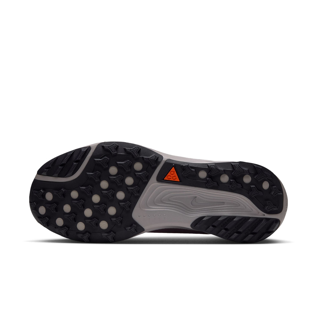 The outsole of a Nike running shoe, showing a black and gray tread pattern with a small orange triangular logo on a white background. - Nike ACG Pegasus Trail Shoes (Women's) - Violet Dust/Purple Dynasty-Safety Orange