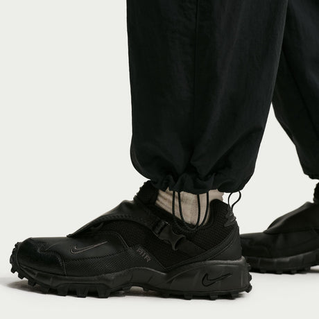 Black Nike shoes worn with black pants on a white background - Nike ACG Dolomiti Pants (Women's) - Black/Summit White