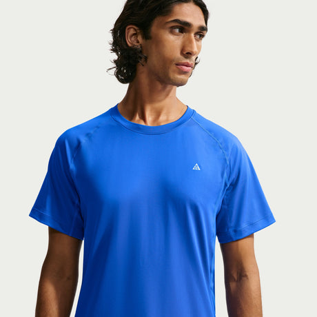 A man wearing a bright blue short-sleeve athletic t-shirt with a small white Adidas logo on the left chest, photographed against a light gray studio background. - Nike ACG Dri-FIT Short-Sleeve Base Layer Top (Men's) - Hyper Royal/Summit White