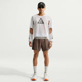 Person wearing a white long-sleeve shirt with cut-out design and brown shorts on a white background - Nike ACG Radical Airflow NXT Dri-FIT Long-Sleeve Trail-Running Top (Men's) - White/Anthracite