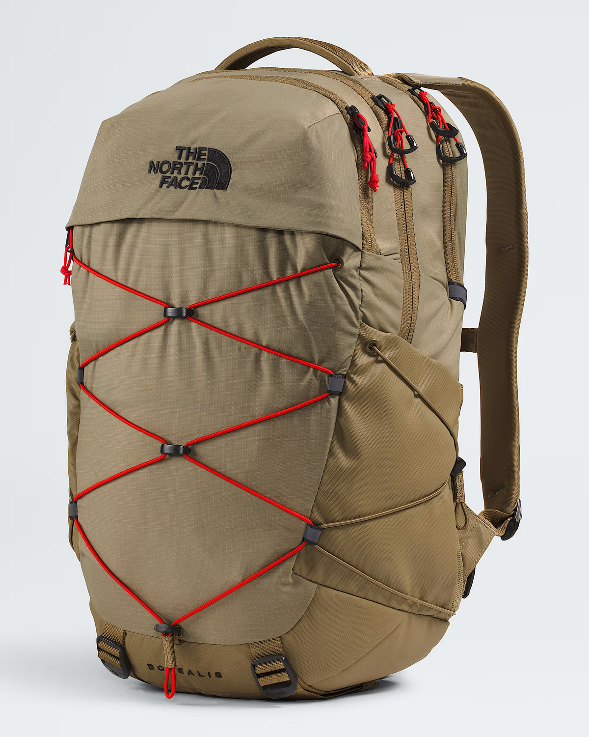 The North Face Balidis backpack in a warm khaki-tan color, featuring prominent red compression straps crisscrossing the front and a black embroidered logo on the upper left. - The North Face Borealis Backpack - Cedar/Lava Red
