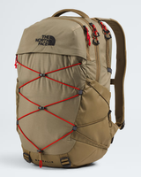 The North Face Balidis backpack in a warm khaki-tan color, featuring prominent red compression straps crisscrossing the front and a black embroidered logo on the upper left. - The North Face Borealis Backpack - Cedar/Lava Red