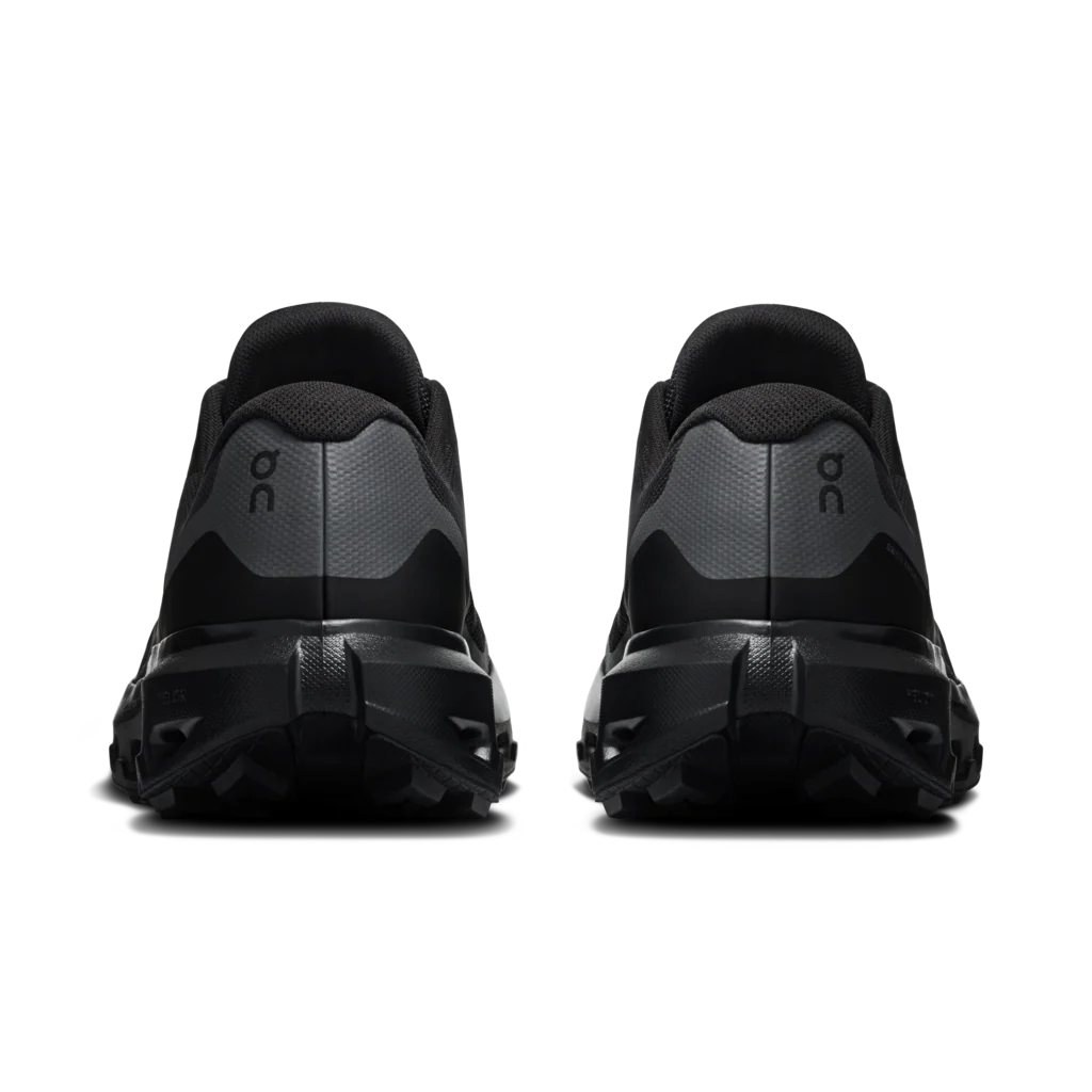 A pair of black and dark gray trail running shoes shown from the rear, featuring the 'on' logo on the heel, set against a plain white background. - On Cloudvista 3 Waterproof Shoes (Men's) - Black