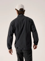 A man viewed from behind wearing a black Arc'teryx lightweight jacket, black pants, and a white baseball cap against a light beige studio background. - Arc'teryx Gamma Jacket (Men's) - Black
