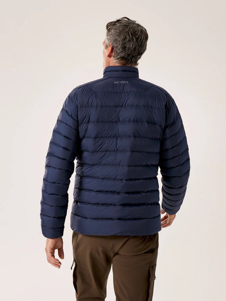 Man wearing a navy puffer jacket on a plain background - Arc'teryx Cerium Jacket (Men's) - Black Sapphire
