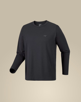 A dark charcoal gray long-sleeve crewneck shirt with a small tonal Arc'teryx logo on the left chest, displayed on a neutral beige background. - Arc'teryx Cormac Crew Neck Shirt Long Sleeve (Men's) - Black