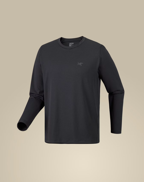 A dark charcoal gray long-sleeve crewneck shirt with a small tonal Arc'teryx logo on the left chest, displayed on a neutral beige background. - Arc'teryx Cormac Crew Neck Shirt Long Sleeve (Men's) - Black