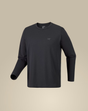 A dark charcoal gray long-sleeve crewneck shirt with a small tonal Arc'teryx logo on the left chest, displayed on a neutral beige background. - Arc'teryx Cormac Crew Neck Shirt Long Sleeve (Men's) - Black