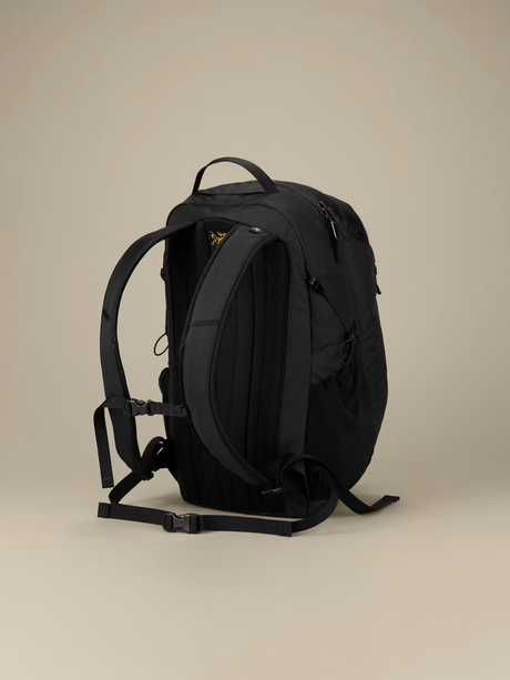 A black backpack shown from the back, featuring padded shoulder straps, a top carry handle, and multiple zippered compartments, photographed against a solid beige studio background. - Arc'teryx Mantis 26L Backpack - Black