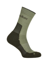An olive green and dark brown hiking sock with the brand name 'Skeaker' printed on the side, shown against a plain white background. - Icebreaker Merino Hike+ Light Crew Socks (Women's) - Lichen/Dark Loden