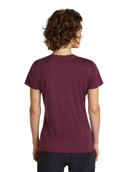 A woman with curly brown hair is shown from the back wearing a short-sleeve crewneck t-shirt in heathered burgundy, paired with black athletic pants, against a plain white background. - Icebreaker Merino 150 Tech Lite Short Sleeve T-Shirt (Women's) - Dark Berry