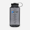 A translucent gray Nalgene water bottle with a black screw cap and carrying loop, shown on a light gray background. The front features the blue and white Nalgene logo and black measurement markings. - Nalgene Wide Mouth Sustain Water Bottle (1L) - Grey/Black
