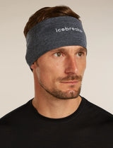 Man wearing a blue headband with 'icebreaker' branding against a neutral background - Icebreaker Merino 200 Oasis Headband (Unisex) - Jet Heather