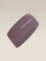 A dusty purple athletic headband with the brand name 'icebreaker' printed in white on the side, shown against a solid beige background. - Icebreaker Merino 200 Oasis Headband (Unisex) - Grey Plum