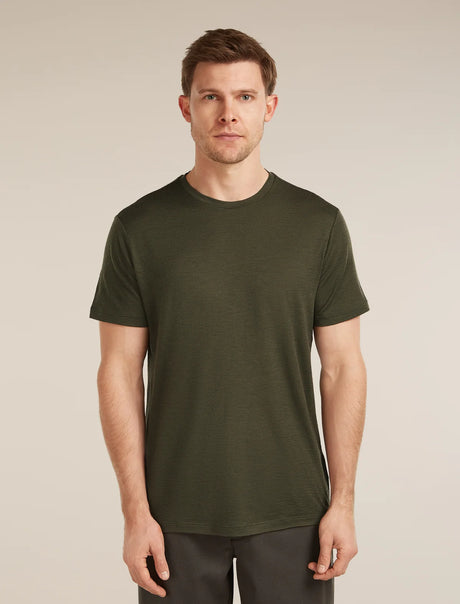 Man wearing a green t-shirt against a beige background - Icebreaker Merino 150 Tech Lite Short Sleeve T-Shirt (Men's) - Dark Loden