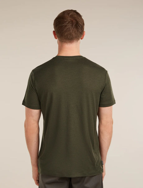 A man viewed from the back wearing a dark olive green short-sleeve crewneck t-shirt, set against a plain beige studio background. - Icebreaker Merino 150 Tech Lite Short Sleeve T-Shirt (Men's) - Dark Loden
