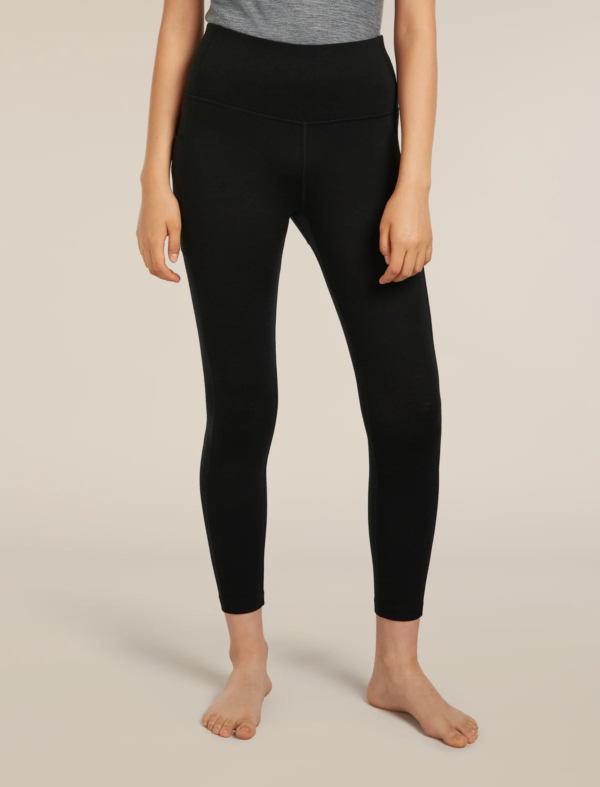 Person wearing black leggings on a beige background - Icebreaker Merino 260 Fastray 25" High Rise Tights (Women's) - Black