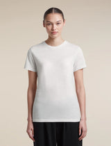 A woman modeling a plain white short-sleeve crewneck t-shirt against a solid beige background. - Icebreaker Merino 150 Tech Lite Short Sleeve T-Shirt (Women's) - Ecru Heather