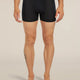 A man modeling black boxer briefs against a plain beige studio background. The waistband shows the brand name 'fjølbrand'. - Icebreaker Merino Blend 125 Cool-Lite Anatomica Boxers (Men's) - Black