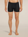 A man modeling black boxer briefs against a plain beige studio background. The waistband shows the brand name 'fjølbrand'. - Icebreaker Merino Blend 125 Cool-Lite Anatomica Boxers (Men's) - Black