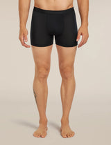 A man modeling black boxer briefs against a plain beige studio background. The waistband shows the brand name 'fjølbrand'. - Icebreaker Merino Blend 125 Cool-Lite Anatomica Boxers (Men's) - Black